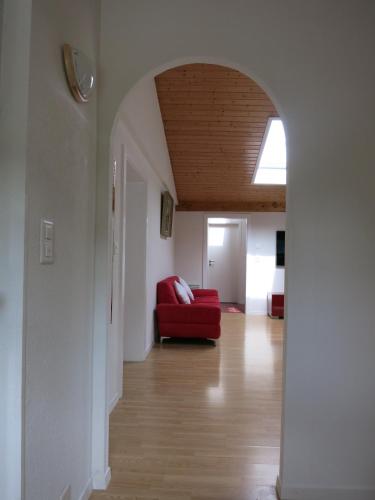 a living room with a red couch and a wooden ceiling at Jade B&B in Bouveret