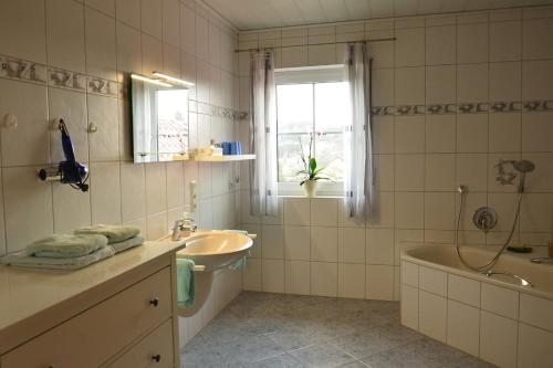 y baño con lavabo, bañera y lavabo. en Urlaub auf dem Bauernhof Marx, en Kelberg