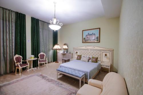 a bedroom with a bed and a table and chairs at Hotel Royal Craiova in Craiova