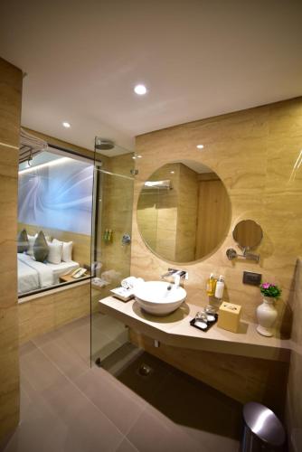 a bathroom with a sink and a shower with a mirror at Nemesia City Center - Gurugram, Sector 29 in Gurgaon