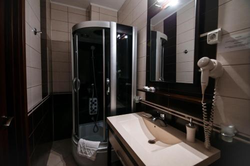 a bathroom with a sink and a shower and a mirror at Hotel Royal Craiova in Craiova