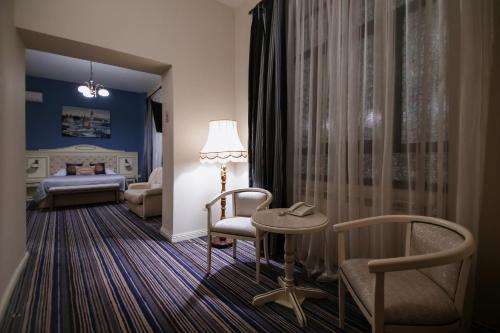 a room with a bed and a table and chairs at Hotel Royal Craiova in Craiova