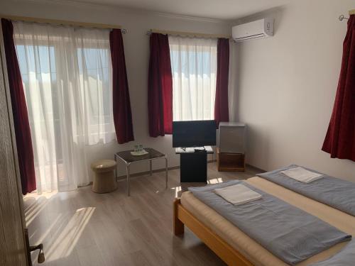 a hotel room with two beds and a television at Aranyszarvas-Goldener Hirsch Pension in Zalakaros