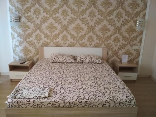 a bedroom with a large bed with two night stands at Hotel Elita in Odesa