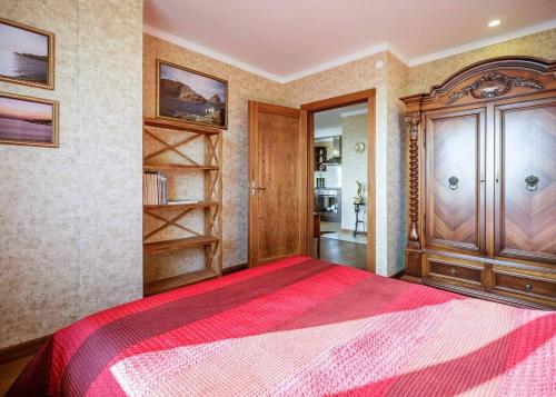 1 dormitorio con 1 cama grande con manta roja en Amber View 15th floor, en Klaipėda
