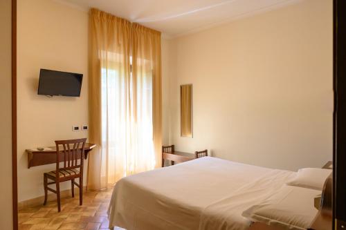 Dormitorio con cama, escritorio y TV en Casa I Cappuccini, en Roma