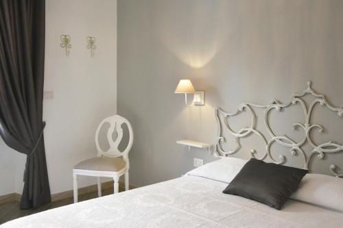 1 dormitorio con 1 cama blanca y 1 silla en Gens Claudia, Vatican Luxury Apartments, en Roma