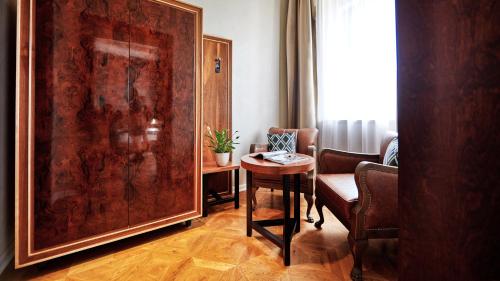 a living room with a table and a large painting at Hotel Alter in Lublin