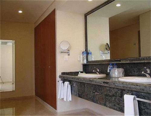 baño con 2 lavabos y espejo grande en Holiday Inn Veracruz-Boca Del Rio, an IHG Hotel, en Veracruz