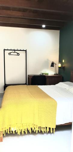 a bedroom with a bed with a yellow blanket on it at Memory Lane in Colombo
