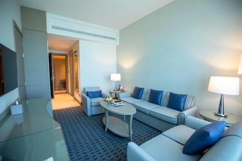 a living room with blue couches and a table at Gulf Inn Hotel Al Nasr Formerly Roda Links Al Nasr in Dubai