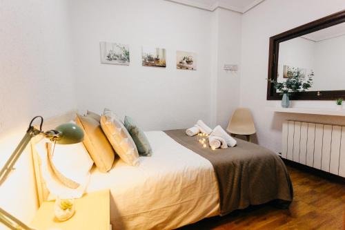a bedroom with a bed and a table with a lamp at Ubicación excelente cerca de Centro Azkuna in Bilbao