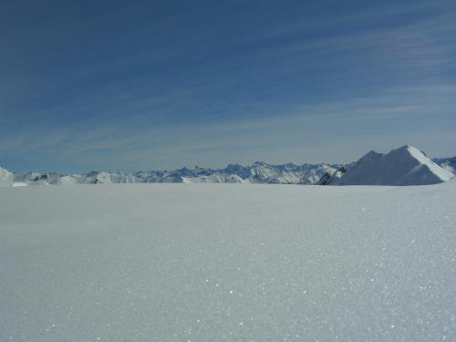 a snow covered field with mountains in the background at Ferienwohnungen Sonderegger in Ischgl