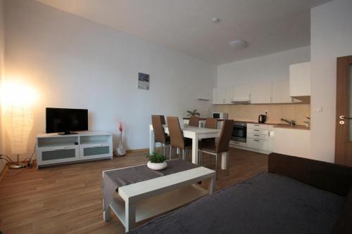 ein Wohnzimmer mit einem Esstisch und einer Küche in der Unterkunft Penzion - Apartments Pod Javořicí in Horní Dubenky