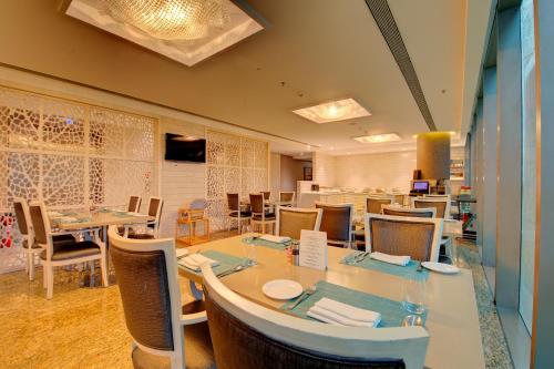 a restaurant with a dining room with tables and chairs at Niranta Transit Hotel Mumbai Airport - At Arrivals in Mumbai