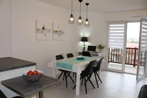 een keuken en eetkamer met een tafel en stoelen bij ZIBURU TERRASSE PARKING TOUT A PIED SAINT JEAN DE LUz in Ciboure