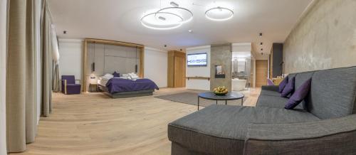 a living room with a couch and a bed at KOSIS Sports Lifestyle Hotel in Fügen