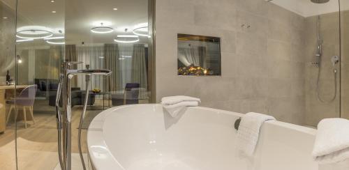 a bathroom with a bath tub and a shower at KOSIS Sports Lifestyle Hotel in Fügen