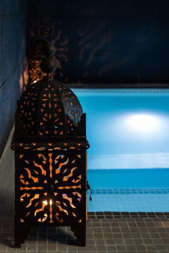 a black lantern sitting next to a swimming pool at Hotel Spa Calagrande Cabo de Gata in Las Negras