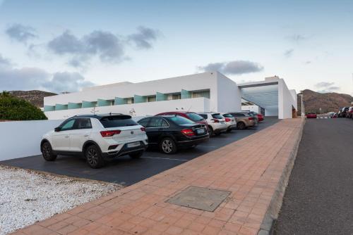 a parking lot with cars parked in front of a building at Hotel Spa Calagrande Cabo de Gata in Las Negras