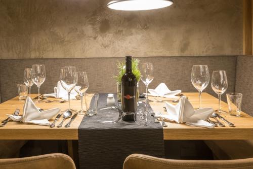 a table with glasses and a bottle of wine on it at KOSIS Sports Lifestyle Hotel in Fügen