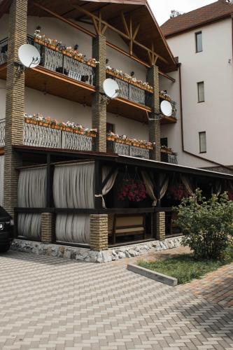 a building with a balcony with flowers on it at Stara Vezha Hotel in Boryspilʼ