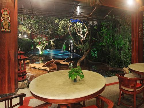 a room with a table and a large aquarium at Green Garden Hotel in Kuta