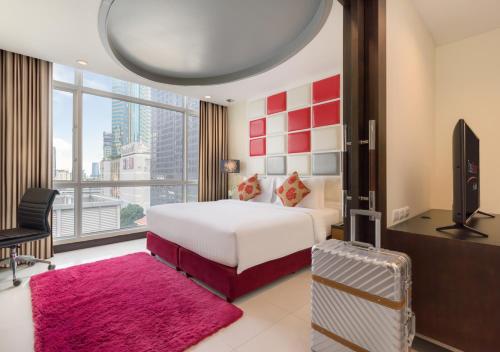 バンコクにあるフラマエクスクルージブ アソークのベッドとテレビが備わるホテルルームです。
