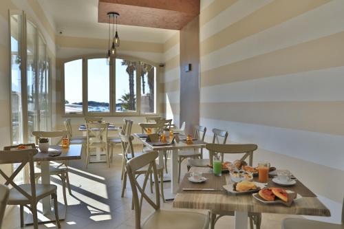 ein Restaurant mit Tischen und Stühlen mit Essen darauf in der Unterkunft B&B Bella Costa - lungomare Porto Cesareo in Porto Cesareo