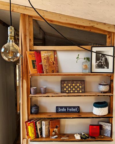 a book shelf with books and other items on it at Barefoot by Barefoot in Tunis in ‘Izbat an Nāmūs