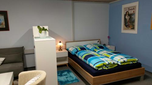 um pequeno quarto com uma cama e um sofá em Inas Ferienwohnungen em Besigheim