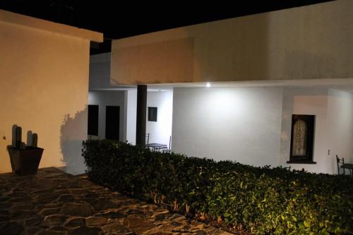 a white building with a hedge in front of it at Casa de Cactus in Bernal