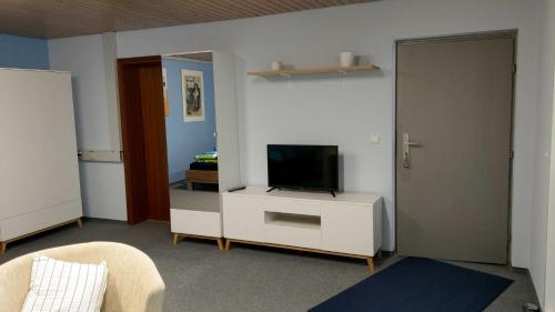 a living room with a television on a white cabinet at Inas Ferienwohnungen in Besigheim