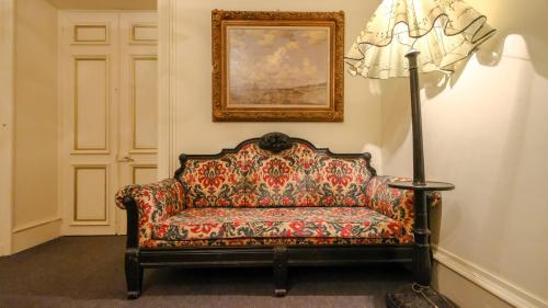 a couch in a room with a painting and a lamp at Private Castle with Park - Château Guillermo in La Moncelle
