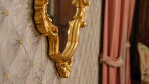a gold mirror hanging on a wall at Private Castle with Park - Château Guillermo in La Moncelle