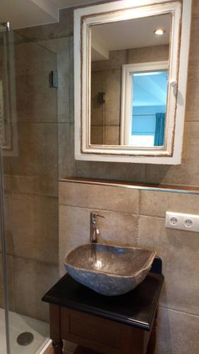 ein Bad mit einem Waschbecken und einem Spiegel in der Unterkunft Die schlafende Goass - Pub und Gästehaus in Bischofswiesen