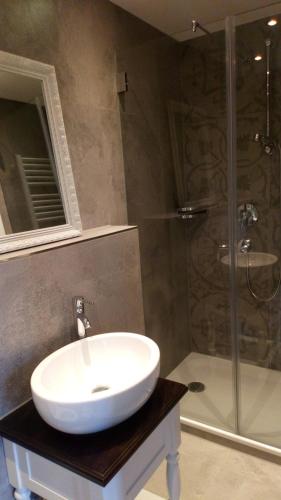 a bathroom with a white sink and a shower at Die schlafende Goass in Bischofswiesen