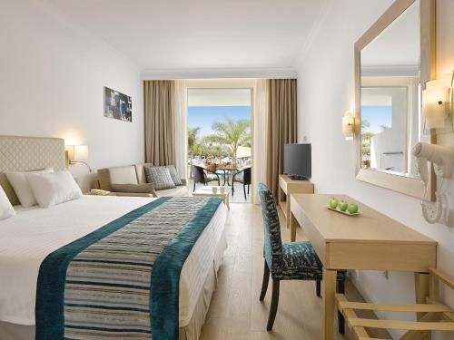 Habitación de hotel con cama y escritorio en Olympic Lagoon Resort Ayia Napa, en Ayia Napa