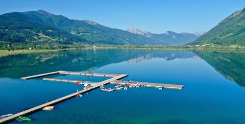 a dock on a lake with mountains in the background at Apartmani Ambiente in Plav