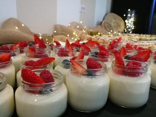 a group of jars of milk with strawberries in them at Hotel Paganella in Molveno