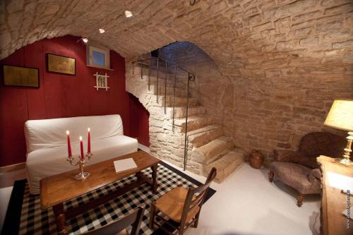 Cette chambre dispose d'une table et d'un mur en pierre. dans l'établissement La Petite Sentence de Noyers, à Noyers-sur-Serein