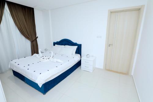 sypialnia z niebiesko-białym łóżkiem i oknem w obiekcie ماجيك سويت بوليفارد Magic Suite Boulevard w Kuwejcie