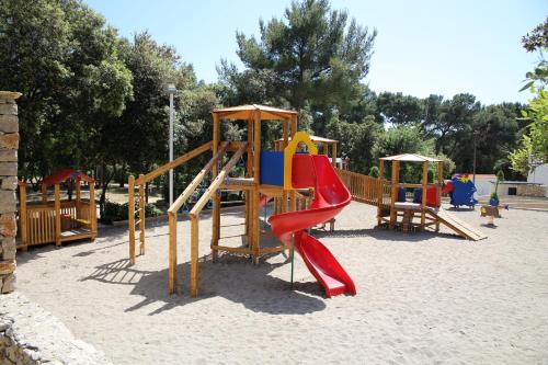 a playground with a slide in a park at Victoria Mobilhome Camping Park Soline in Biograd na Moru