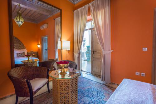 a room with a table and chairs and a bed at Riad Azoulay in Marrakech