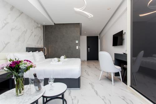 a hotel room with a bed and a table and chairs at Crystal villas & suites in Polykhrono