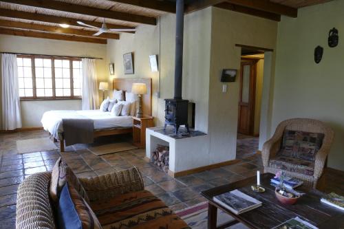 1 dormitorio con 1 cama y sala de estar en The Retreat at Groenfontein, en Calitzdorp