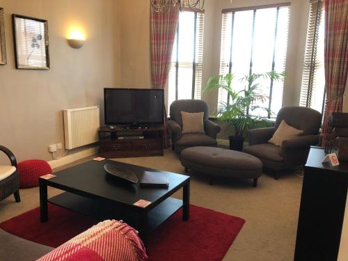 a living room with a tv and a coffee table at Number 10 service apartment - Danes in Southampton