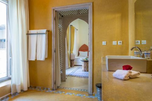 a bathroom with a tub and a large mirror at Riad Azoulay in Marrakech