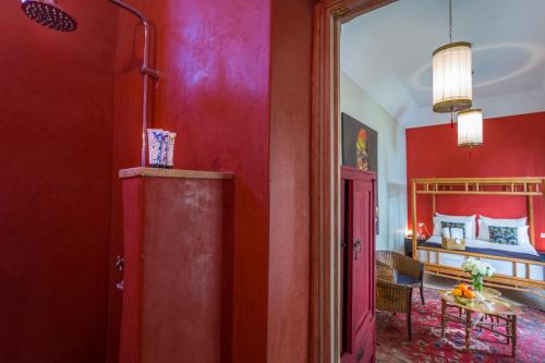 a room with red walls and a room with a bed at Riad Azoulay in Marrakech