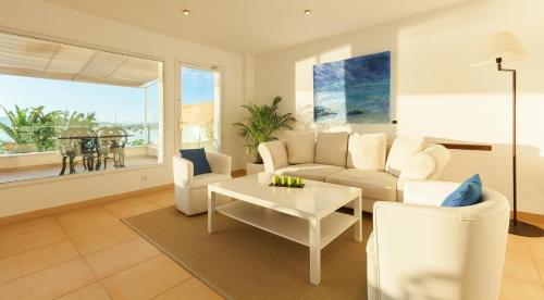 a living room with a white couch and a table at Hotel Capri in Port de Pollensa